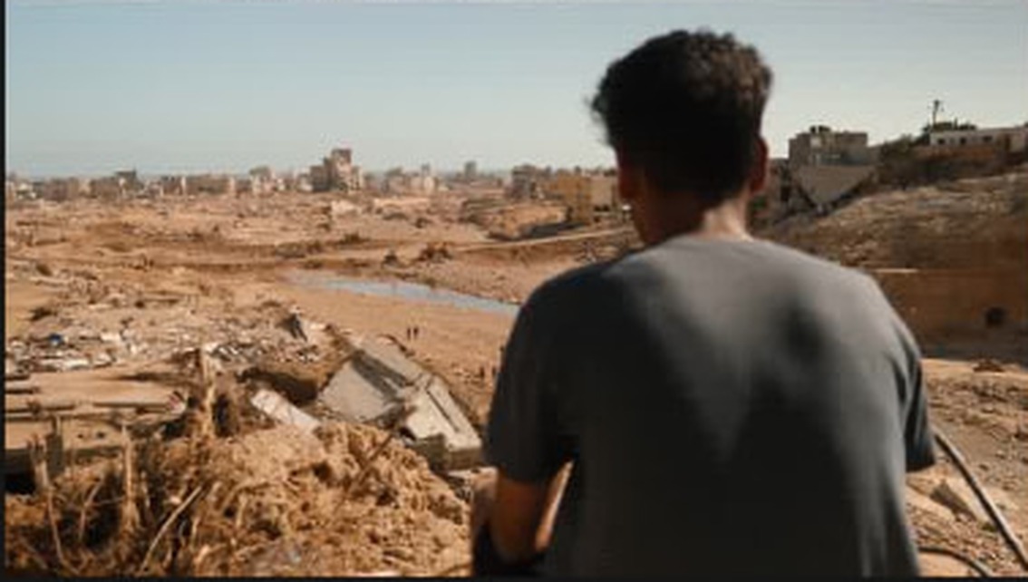 A young man looking out over the changed riverbed