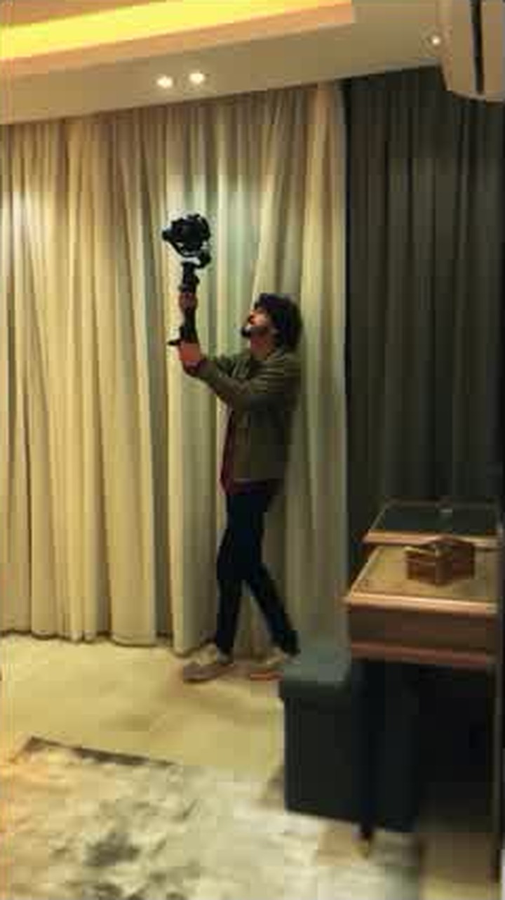 Asaad filming a handheld gimbal shot indoors
