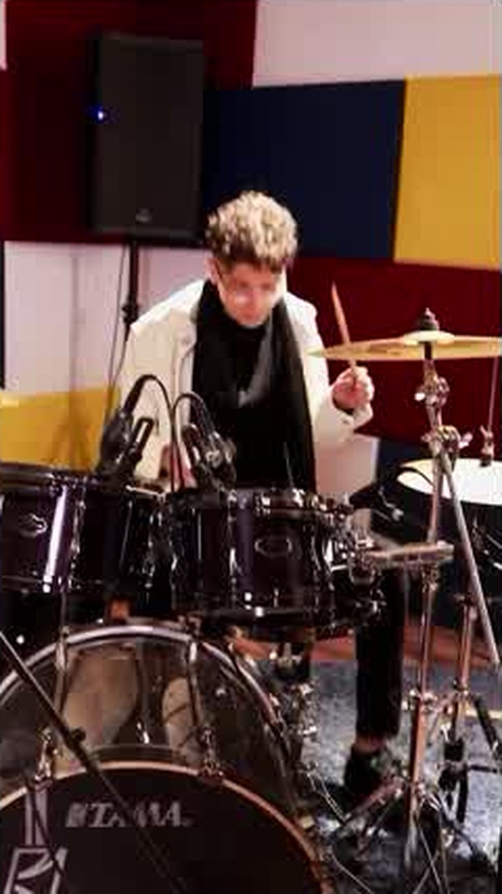 Asaad behind a drum kit mid-performance