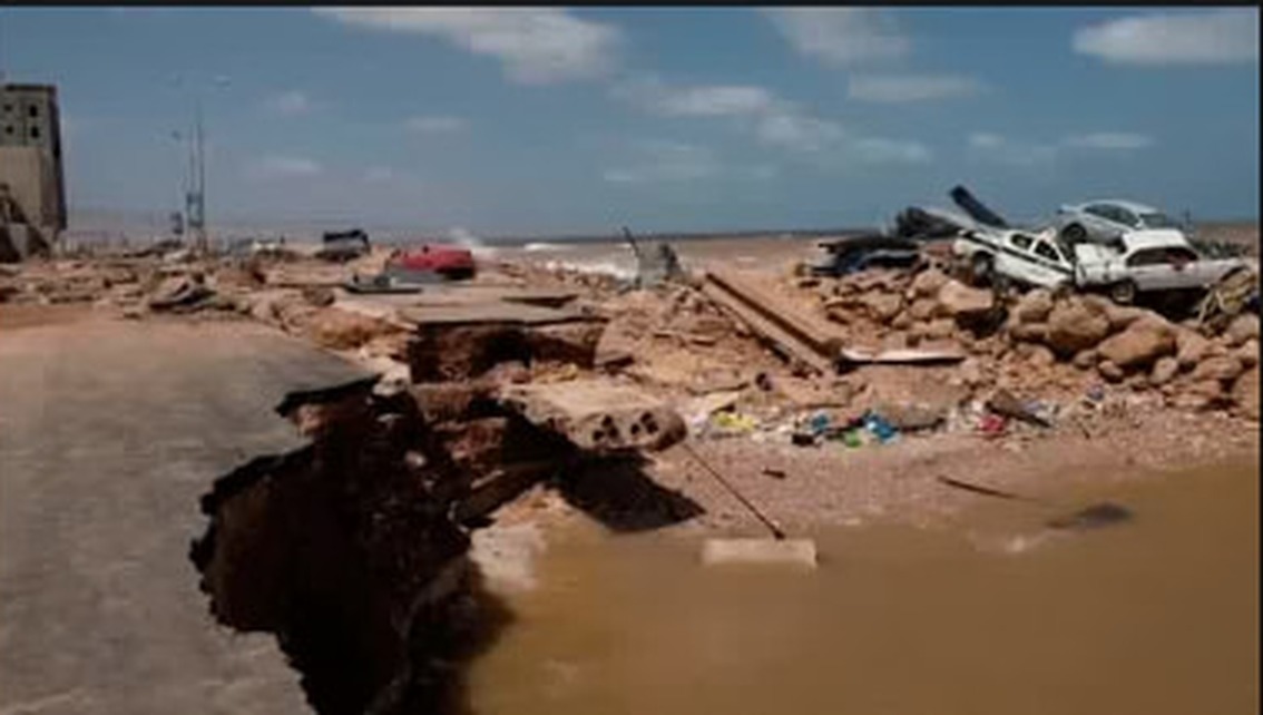 A road split open beside collected debris