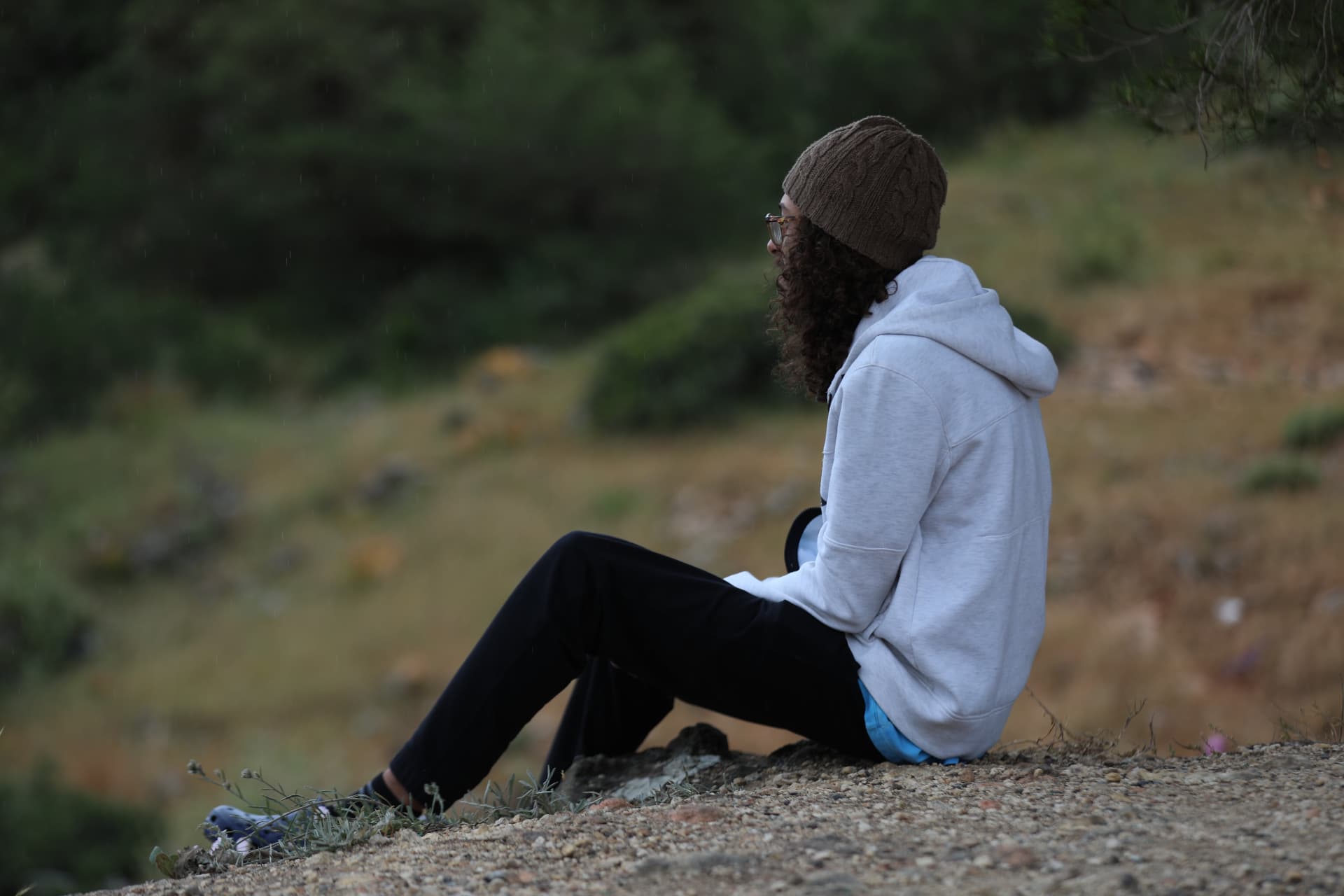 Seated on a hillside between locations, looking out over the landscape
