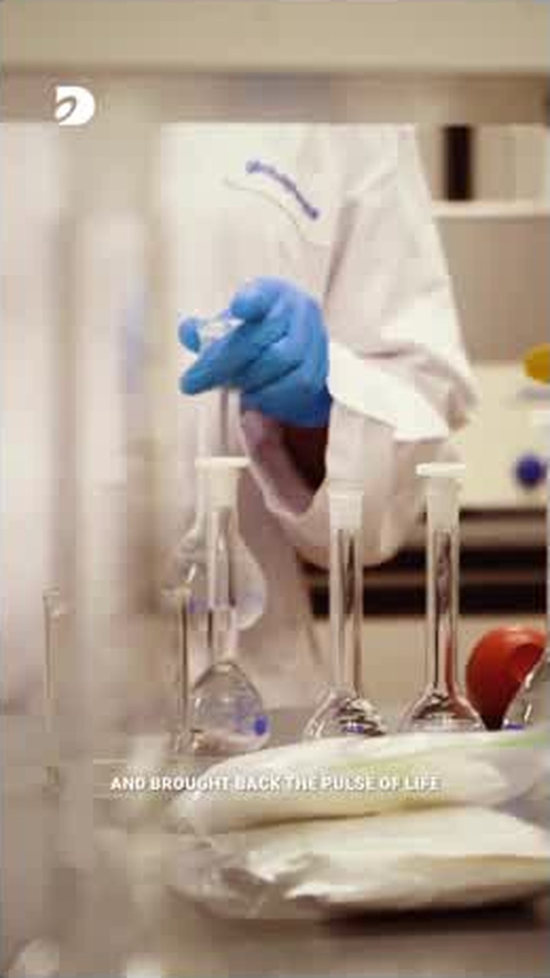 A gloved hand working with laboratory glassware — healthcare and innovation
