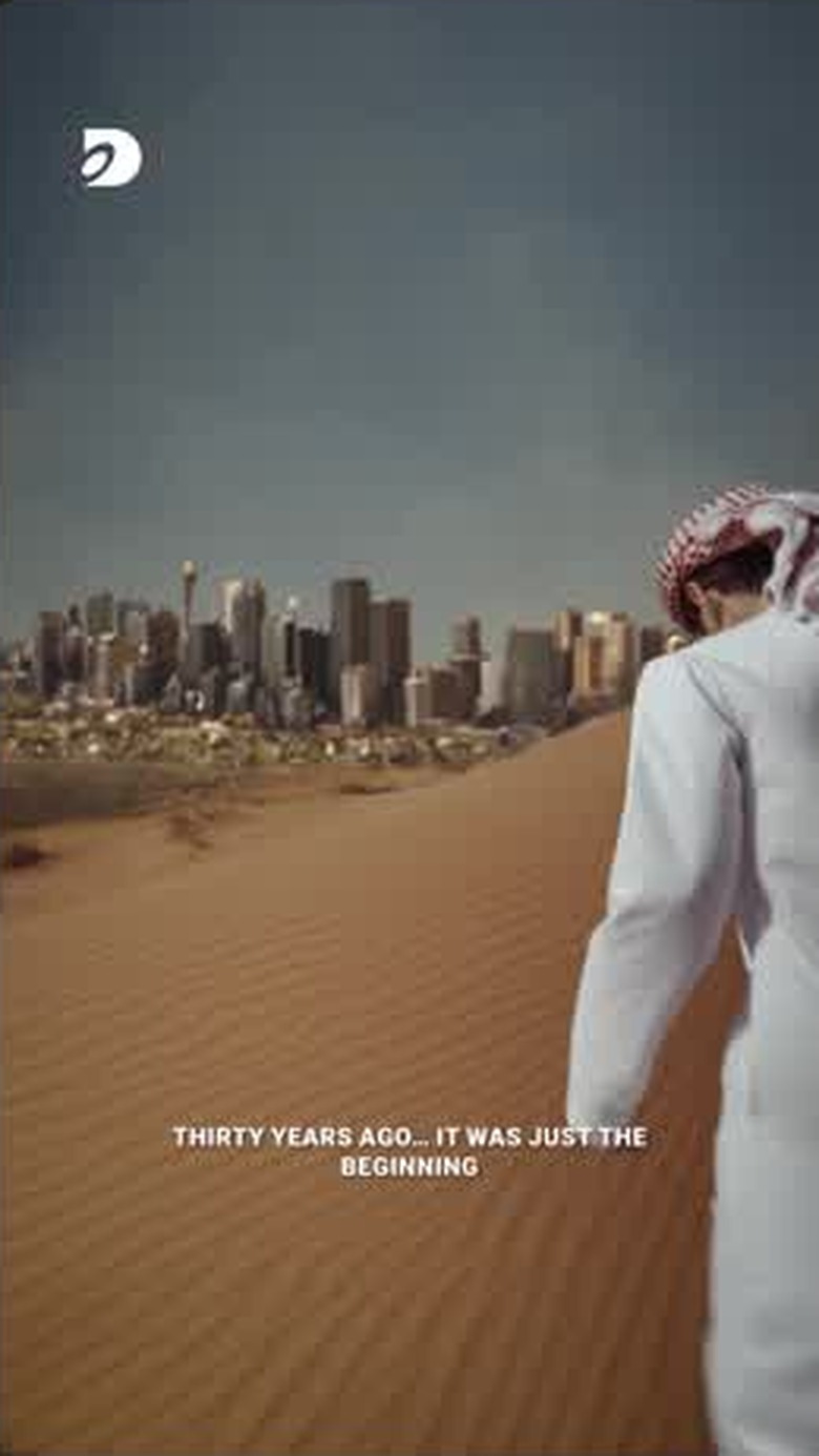 The younger figure facing the completed skyline from the dune